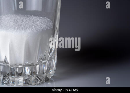Lo zucchero cristallizzato in un bicchiere di vetro. Foto Stock