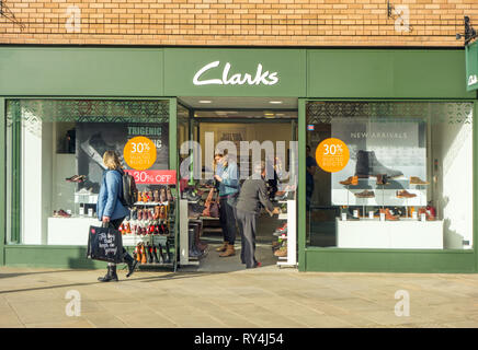 Le donne amanti dello shopping shopping e cercando nella finestra di Clarks negozio di scarpe Foto Stock