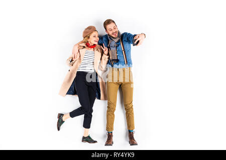 Donna elegante che mostra segni di pace tenendo selfie con il mio ragazzo su sfondo bianco Foto Stock