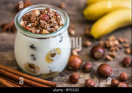 Servire di yogurt con muesli, banana e dadi Foto Stock