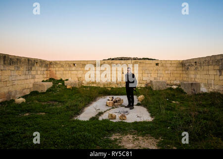 Turisti maschio sulla bellissima Ghajn Tuffieha Bay prese durante il tramonto colorato sull isola di Malta. Bellissimo paesaggio nel sud Europa. Foto Stock