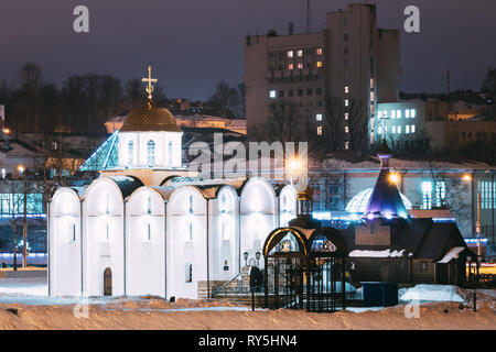 Vitebsk, Bielorussia. Vista invernale della Chiesa dell'Annunciazione e la chiesa in legno di San Alexander Nevsky In illuminazione notturna Foto Stock