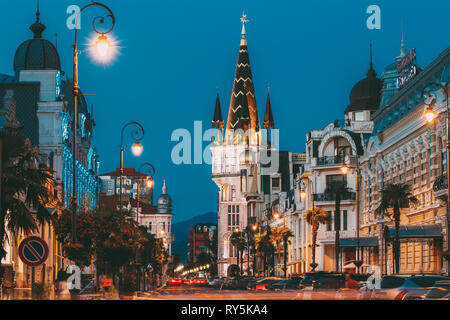 Batumi, Adjara, Georgia. Vista serale sulla Ex Banca Nazionale edificio con orologio astronomico in piazza Europa Foto Stock