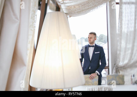 Elegante lo sposo in una camera di hotel Foto Stock