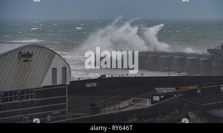 Brighton, Regno Unito. Xii Mar, 2019. Onde infrangersi su Brighton Marina parete occidentale questa mattina come tempesta Gareth inizia a pastella la Gran Bretagna e l'Irlanda con venti dovrebbe raggiungere oltre 70mph in alcune parti Credito: Simon Dack/Alamy Live News Foto Stock