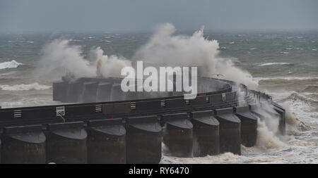 Brighton, Regno Unito. Xii Mar, 2019. Onde infrangersi su Brighton Marina parete occidentale questa mattina come tempesta Gareth inizia a pastella la Gran Bretagna e l'Irlanda con venti dovrebbe raggiungere oltre 70mph in alcune aree Credito: Simon Dack/Alamy Live News Foto Stock