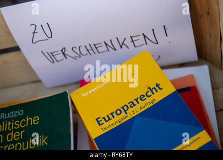 12 marzo 2019, il Land della Baviera, München: un pezzo di carta con la scritta 'Zu verschenken!' appeso su una casella sulla strada, che contiene vari codici e la ventiduesima edizione del diritto europeo. Foto: Peter Kneffel/dpa Foto Stock