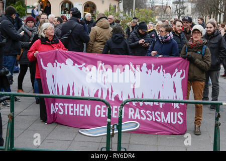 Worm, Germania. Xii Marzo 2019. Contro i manifestanti di tenere un banner che recita "stand up contro il razzismo". Il gruppo parlamentare del Landtag (parlamento) della Renania Palatinato del diritto-ala partito AfD (alternativa per la Germania) ha organizzato una veglia di worm per Syndia R., che è stato ucciso da un richiedente asilo. Credito: Michael Debets/Alamy Live News Foto Stock