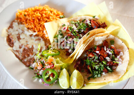 Angolo di alta vista di tacos con pasto servito nella piastra sulla tavola Foto Stock