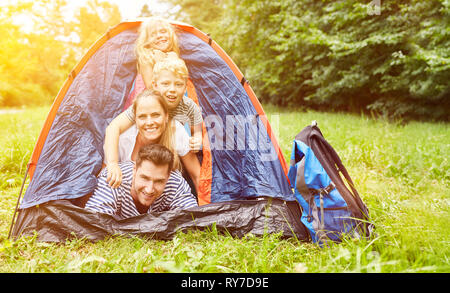 Felice famiglia con due bambini in tenda mentre il campeggio in campeggio Foto Stock
