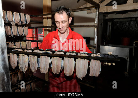 Materie con salmone essendo preparato per fumare a Mori con salmone, un azienda di famiglia sin dal 1770, in Peel sulla costa occidentale dell'Isola di Man, Gran Bretagna. A pochi Foto Stock