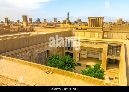 Yazd Città Vecchia Cityscape con tetto cortile Badgir Windcatcher moschea minareto a cupola Foto Stock