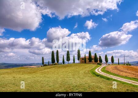 Toscana, Italia - Luglio 6, 2018: cipressi e prato con tipica casa toscana, Val d'Orcia, Italia - Toscana Foto Stock
