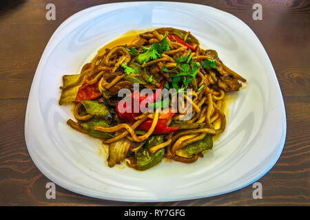 Kyrgyzstani fritto Lagman piccante tagliatelle con peperone rosso e verdure Foto Stock