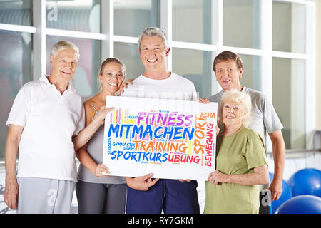 Seniors tenere poster nel centro fitness con parola chiave cloud sul fitness Foto Stock
