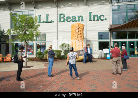 I visitatori di prendere una foto ricordo con il novantesimo anniversario bean boot nella parte anteriore del LL Bean store in Freeport, Maine, Stati Uniti d'America. Foto Stock