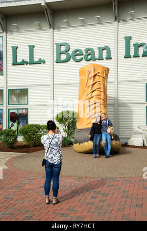 I visitatori di prendere una foto ricordo con il novantesimo anniversario bean boot nella parte anteriore del LL Bean store in Freeport, Maine, Stati Uniti d'America. Foto Stock