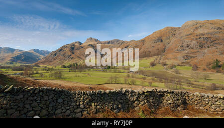 Un ampio angolo di visione della bella langdale valley e The Langdale pikes con verdi campi e montagne aspre sotto Belle Blue Skies con Foto Stock