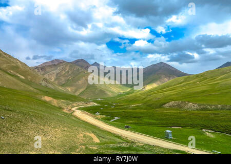 Tash Rabat Caravanserai paesaggio con Snow capped a Bashy troppo la gamma della montagna di auto e il fiume su strada Foto Stock