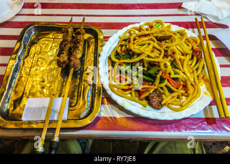 Tradizionale uigura Piccante spiedini di agnello con cumino e Lagman tagliatelle piatto Foto Stock