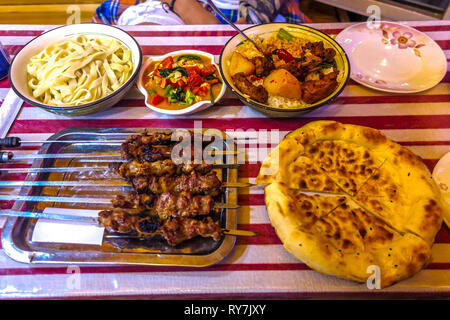 Tradizionale uigura Piccante spiedini di agnello con cumino e pane Naan Foto Stock