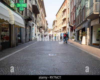 LECCO, Italia - 20 febbraio 2019: i turisti a piedi su via Camillo Benso Conte di Cavour nella città di Lecco in serata. Lecco è una città in Lombardia, il c Foto Stock