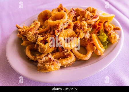 Tradizionale Greca calamari fritti Kalamaria Tiganita su una piastra bianca Foto Stock