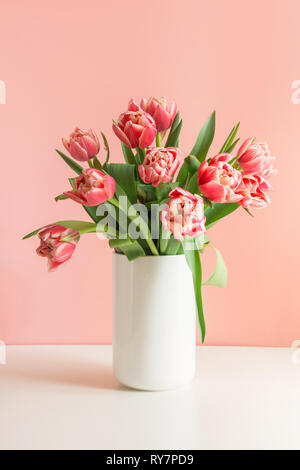 Bouquet di tulipani rossi in vaso sulla millenaria rosa. Foto Stock