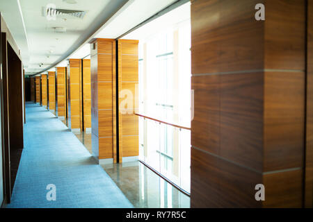 Hall con colonne di legno, moquette blu sul pavimento Foto Stock