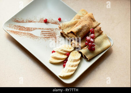 Dessert frittelle calde con cioccolato da spalmare e banana. Decorate con uve secche di Corinto.dessert. Foto Stock