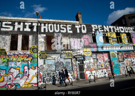 Londra. Hackney Wick. Vecchio edificio accovacciata coperto di graffiti Foto Stock