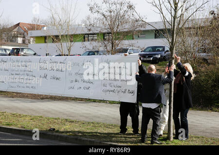 Wiesbaden, Germania. Xii Mar, 2019. Manifestanti appendere un banner outsider la casa corte. La causa in tribunale contro il governo iracheno richiedente asilo Ali B. Per l assassinio di Susanna F. da Mainz lo scorso anno è stato aperto a Wiesbaden. Varie aletta destra organizzazioni tenute una protesta al di fuori della Corte casa contro i rifugiati in Germania e per pene più severe per i rifugiati. Credito: Michael Debets/Pacific Press/Alamy Live News Foto Stock