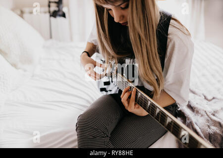 Giovane brunetta Donna suona la chitarra Foto Stock