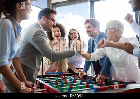 La gente di affari di grande tempo insieme.i colleghi tavolo da gioco calcio in ufficio. Foto Stock