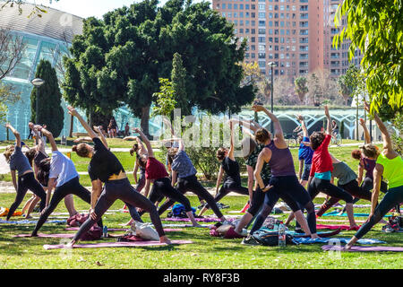 Nel Parco Turia di Valencia, la gente si incontra nel giardino e pratica yoga gruppo classe Valencia Spagna parco della città folla sano stile di vita giardino yoga Foto Stock