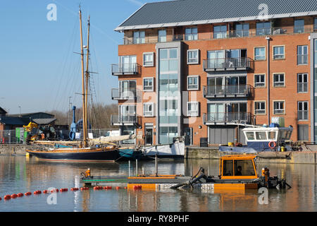 Bloccare le riparazioni e dragaggio presso il bacino principale di Gloucester Docks nell Inghilterra del sud Foto Stock