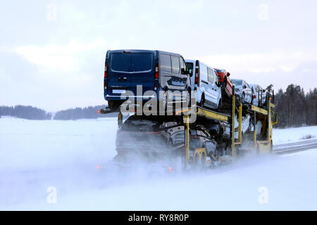 Auto vettore carrello trasporta un carico di veicoli su un giorno di nevicate invernali, in vista posteriore Salo, Finlandia. Il 18 gennaio 2019. Foto Stock