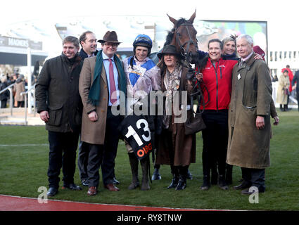 Jockey Harry Skelton (quarta a sinistra) con trainer Dan Skelton (sinistra) e connessioni vincente dopo Roksana vince il OLBG Mares' ostacolo durante il giorno campione del 2019 Cheltenham Festival a Cheltenham Racecourse. Foto Stock