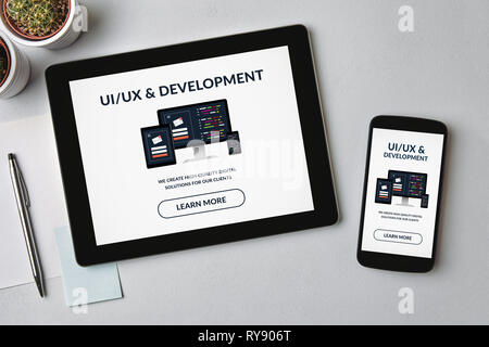 UI/UX design e concetto di sviluppo su tablet e lo schermo dello smartphone su tabella grigia. Tutti i contenuti della schermata è progettato da me. Lay piatto Foto Stock
