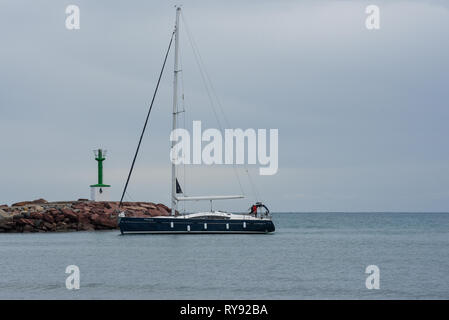 Una barca a vela entra in porto Foto Stock