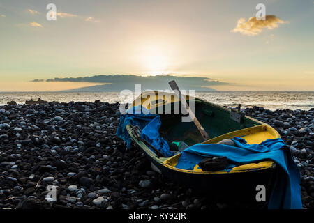 In legno barca a remi su terreni sassosi spiaggia al tramonto con isola all'orizzonte, Fonsalia, Tenerife, Isole Canarie, Spagna Foto Stock