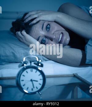 Insonne e disperato bella donna caucasica sveglio di notte non è in grado di dormire, sentendosi frustrato e preoccupata guardando alla sofferenza di clock da ins Foto Stock