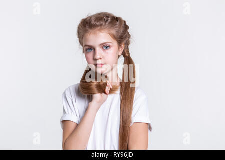 Grave carino con i capelli lunghi lady raccogliendo i suoi capelli in pugno Foto Stock