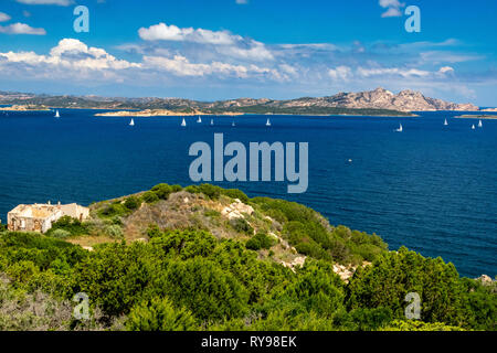 Vista colorate del litorale del nord Sardegna e le isole di La Maddalena e l'Isola di Caprera con barche e una rovina- Baia Sardinia, SARDEGNA. Foto Stock