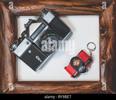 Due vecchi giacciono fotocamera in cornice di legno su uno sfondo bianco, close-up Foto Stock