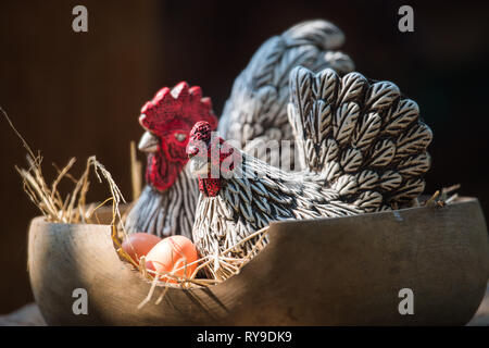 Clay gallina e uovo, stampato da argilla e attraverso il calore, nel cesto di legno. Foto Stock