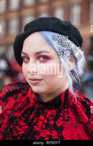 Londra - 17 febbraio 2019: Elegante partecipanti al di fuori di raccolta 180 del filamento per la London Fashion Week. ragazza con i capelli viola con le forcine in un berretto Foto Stock
