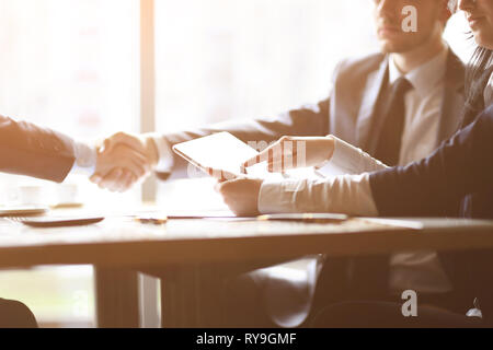 Imprenditore utilizza una tavoletta digitale a una riunione di affari Foto Stock