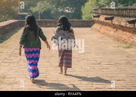 Backview femminile di turisti alla antica Pa Hto Taw Gyi Pagoda rovine a Mingun città vicino a Mandalay, Myanmar. Foto Stock