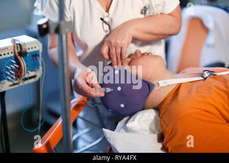 Giovane uomo durante esame elettroencefalografico Foto Stock